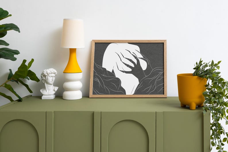 May include: A modern interior scene features a green cabinet with a white bust, a yellow and white lamp, and a framed black and white art print. A yellow planter with greenery adds a pop of color.