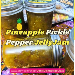 Pode incluir: Vários frascos de vidro cheios de Pineapple Pickle Pepper JellyJam. Os frascos têm tampas prateadas e são preenchidos com uma geleia amarelo-esverdeada. O texto "Pineapple Pickle Pepper JellyJam" é exibido em letras amarelas grandes.