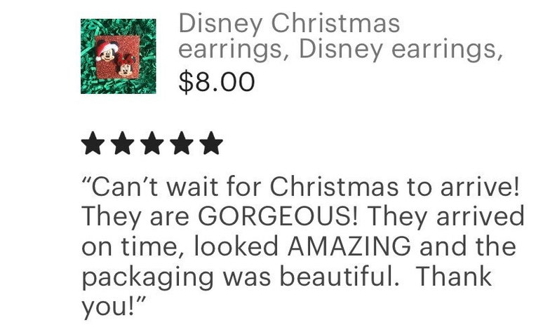 May include: A pair of Christmas-themed earrings featuring Mickey Mouse and Minnie Mouse wearing Santa hats. The earrings are red, black, and white.