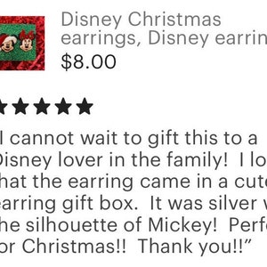 May include: A pair of Christmas-themed earrings featuring Mickey Mouse and Minnie Mouse. The earrings are displayed in a small gift box with a silver Mickey Mouse silhouette. "I cannot wait to gift this to a Disney lover in the family! I love that the earring came in a cute earring gift box. It was silver with the silhouette of Mickey! Perfect for Christmas!! Thank you!"