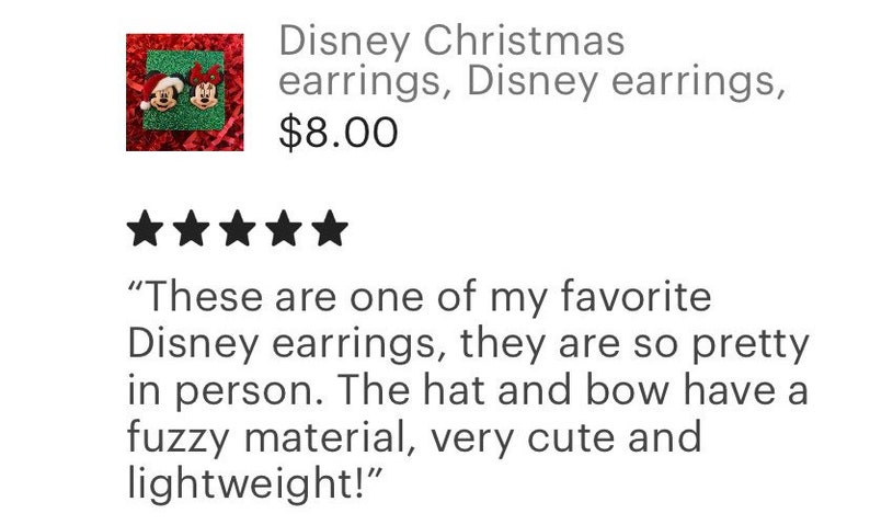 May include: A pair of Christmas-themed Disney earrings featuring Mickey Mouse and Minnie Mouse. Mickey is wearing a Santa hat and Minnie is wearing a red bow. The earrings are made of a fuzzy material.