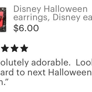 May include: A pair of Disney Halloween earrings, featuring a Mickey Mouse design. The earrings are displayed on a red card with a polka dot pattern, surrounded by silver confetti. The text reads "Disney Halloween earrings, Disney earrings."