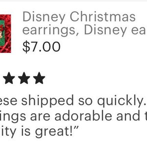 May include: A pair of Christmas-themed earrings featuring Mickey Mouse and Minnie Mouse wearing Santa hats. The earrings are red and green and have a festive feel.