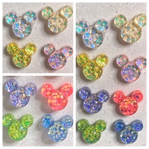 Op de afbeelding: Assortiment van 10 paar iriserende glitter Mickey Mouse oren in verschillende kleuren, waaronder blauw, groen, geel, roze en paars.