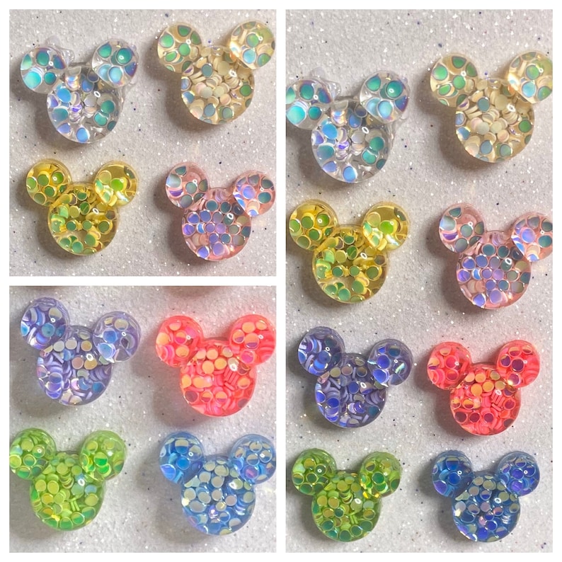 Op de afbeelding: Assortiment van 10 paar iriserende glitter Mickey Mouse oren in verschillende kleuren, waaronder blauw, groen, geel, roze en paars.