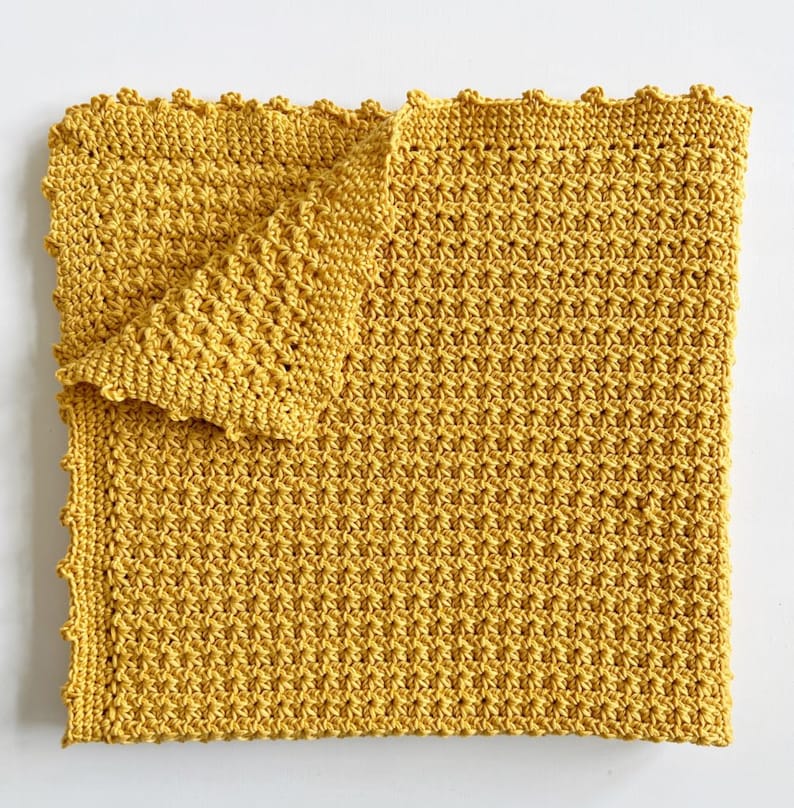 Pu&ograve; includere: Una copertina per neonati all'uncinetto di colore giallo brillante con un bordo a festoni.