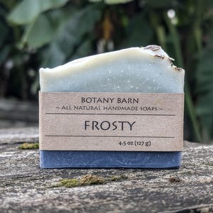May include: A bar of blue and white soap with a brown label that reads "Botany Barn ~ All Natural Handmade Soaps ~" and "Frosty 4.5 oz (127 g)"