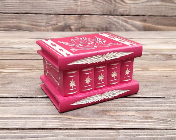 A handcrafted wooden keepsake box with a hidden secret compartment that only opens via a puzzle mechanism — functional mystery object and a genuinely memorable gift.