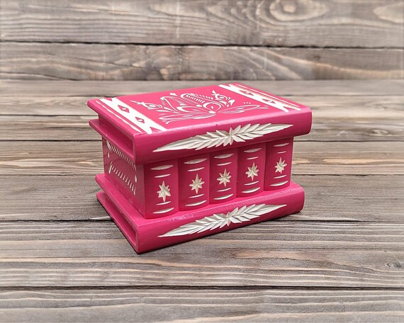 A handcrafted wooden keepsake box with a hidden secret compartment that only opens via a puzzle mechanism — functional mystery object and a genuinely memorable gift.