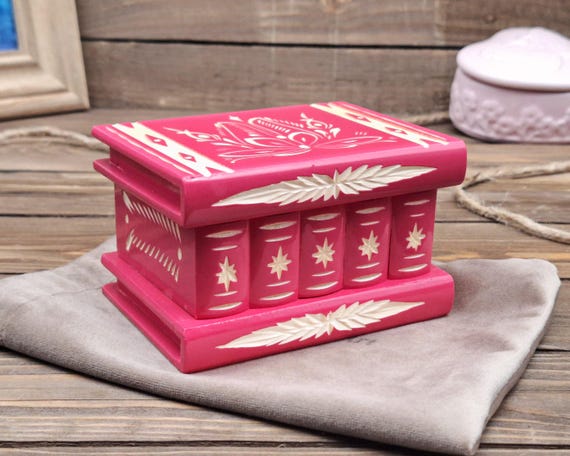 A handcrafted wooden keepsake box with a hidden secret compartment that only opens via a puzzle mechanism — functional mystery object and a genuinely memorable gift.
