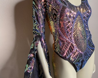 May include: A black long-sleeved bodysuit with iridescent sequins and a sheer mesh overlay. The bodysuit has a V-neck and bell sleeves.