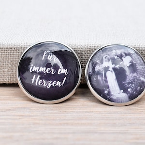 Könnte beinhalten: Zwei runde Foto-Knöpfe mit silbernem Rand. Ein Knopf hat einen schwarzen Hintergrund mit weißem Text, der "Für immer im Herzen!" lautet. Der andere Knopf zeigt ein Schwarzweißfoto einer Hochzeitsgesellschaft.