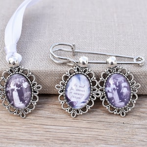 Könnte beinhalten: Drei silberne ovale Bilderrahmen mit einem weißen Satinband. Die Rahmen haben ein filigranes Design und zeigen Schwarzweißfotos. Ein Rahmen hat den Text "I's said for, amors in unsere Herzen!" auf dem Glas gedruckt.