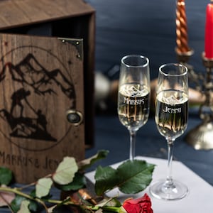 May include: Two champagne flutes with the names "Markus" and "Jenni" etched on them, a single red rose, and a wooden box with the names "Markus & Jenni" on the front.
