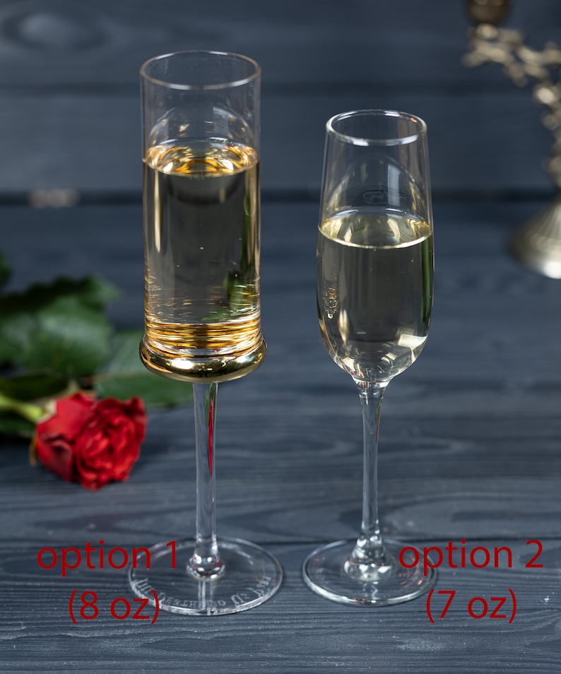 May include: Two champagne flutes, one with a gold rim, filled with a clear sparkling beverage. The flute on the left is labeled "option 1 (8 oz)" and the flute on the right is labeled "option 2 (7 oz)".