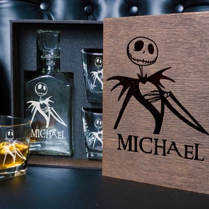 May include: A wooden box set with a glass decanter and four glasses. The decanter and glasses are etched with a cartoon character and the name "MICHAEL".
