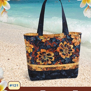 May include: A blue and orange floral tote bag with 16 pockets. The bag is labeled "Tuscany Tote" and is designed by Pink Sand Beach Designs. The bag is fat quarter friendly and includes color picture instructions.