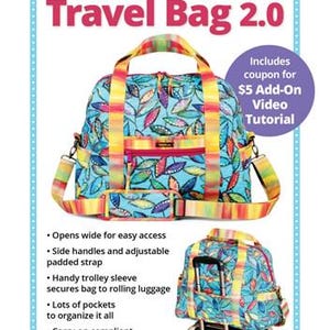 May include: A blue travel bag with a colorful leaf pattern, featuring yellow and red accents. The bag has a shoulder strap and handles. Text on the image reads "Ultimate Travel Bag 2.0" and "The perfect travel companion!"
