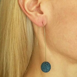 Earrings handmade long, wire with lava bead in blue color.