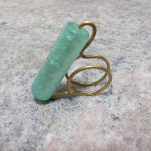Anillo hecho a mano con alambre de bronce y cuenta de acrílico turquesa.