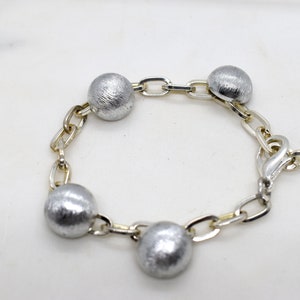 Handmade chain bracelet for women with stainless steel and round relief element.