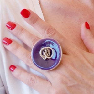 Ring a coconut wooden handmade button with purple resin on its face by being set upon a brass wire.