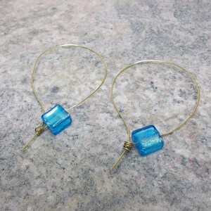 Handmade earrings with wire gilded and blue glass beads.