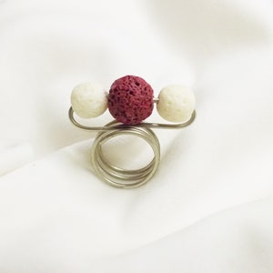 Handmade ring from bronze wire with brown lava and white coral stones.