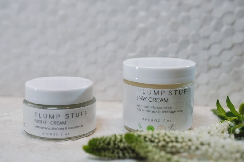 May include: Two white jars of face cream with the label "PLUMP STUFF" on them. The smaller jar is labeled "NIGHT CREAM" and the larger jar is labeled "DAY CREAM".