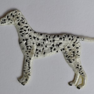 May include: White embroidered patch of a Dalmatian dog with black spots. The dog is standing with its head turned to the left.