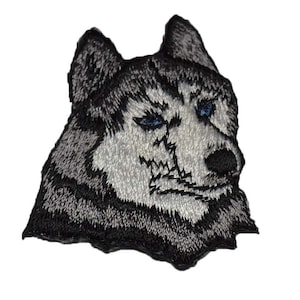 May include: Embroidered patch of a wolf's head with a black and gray fur pattern and blue eyes. The wolf has a fierce expression.