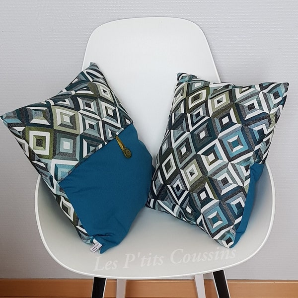 Decorative cushion cover with geometric diamond patterns in shades of green and duck blue