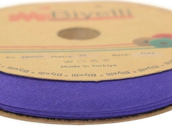 May include: A roll of purple fabric ribbon on a cardboard spool. The spool has the text "Biyelli" printed on it, along with the text "Made in Türkiye".