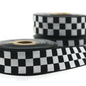Peut inclure: Ruban à carreaux noir et blanc avec un fond blanc et des carrés noirs. Le ruban est enroulé et prêt à être utilisé pour l'artisanat, la décoration ou l'emballage de cadeaux.