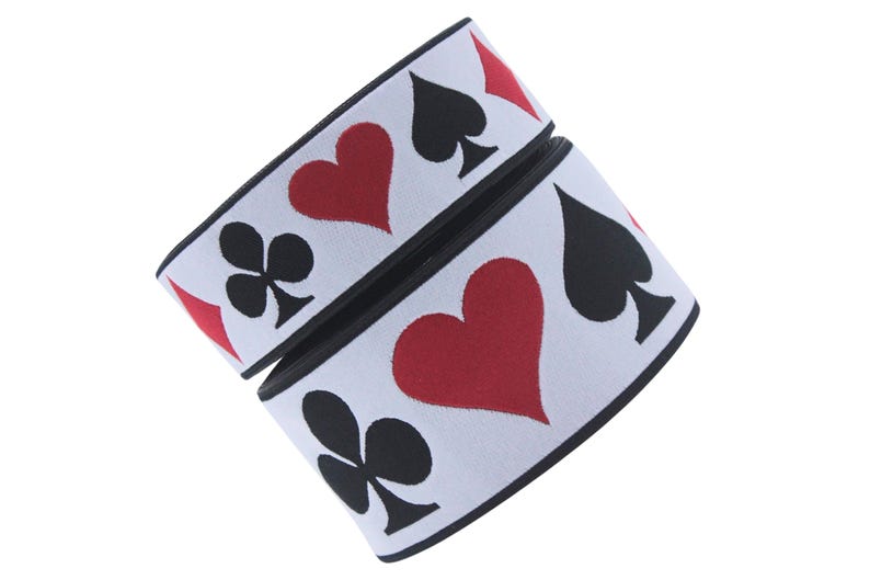 May include: White elastic with black and red playing card symbols. The symbols are hearts, spades, and clubs.