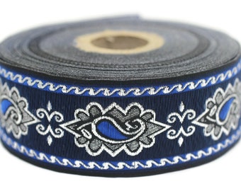 Puede incluir: Un rollo de ribete azul y plateado con un patrón de paisley. El ribete tiene aproximadamente 2,5 cm de ancho.
