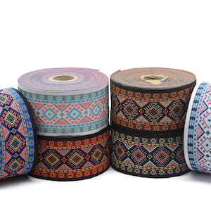 Pode incluir: Cinco rolos de fita estampada colorida com desenhos geométricos. A fita é tecida com uma variedade de cores, incluindo azul, rosa, laranja e preto.