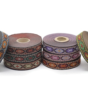 May include: Four spools of colorful patterned ribbon with geometric designs. The ribbon is black with multi-colored embroidery. The ribbon is wound around spools with a brown, purple, and black base.