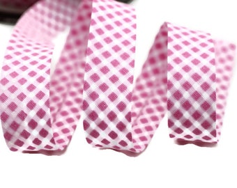 Könnte beinhalten: Rosa-weißes Gingham-Band mit einem karierten Muster. Das Band ist gekräuselt und verdreht.