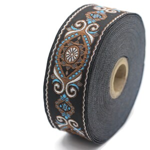 May include: A roll of black trim with a brown and blue patterned design. The trim has a repeating pattern of swirls and diamonds.