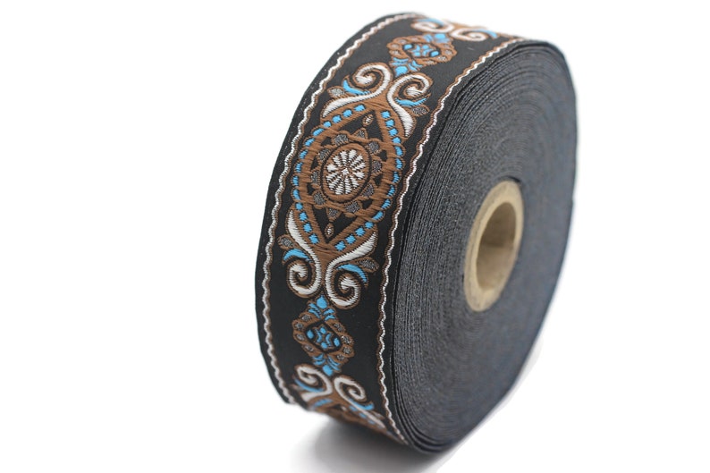 May include: A roll of black trim with a brown and blue patterned design. The trim has a repeating pattern of swirls and diamonds.