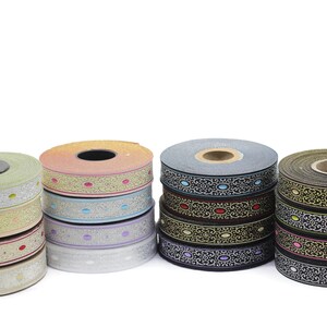Peut inclure: Assortiment de bobines de ruban à motifs colorés avec différents motifs et couleurs, notamment or, argent, noir, rouge et bleu.