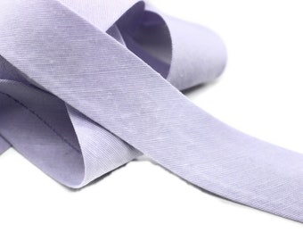 May include: A light purple fabric ribbon with a textured surface.