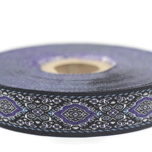 May include: A roll of black trim with a purple and silver patterned design. The trim has a geometric pattern with a diamond shape in the center.