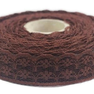 May include: A roll of brown lace trim with a scalloped edge and floral pattern.