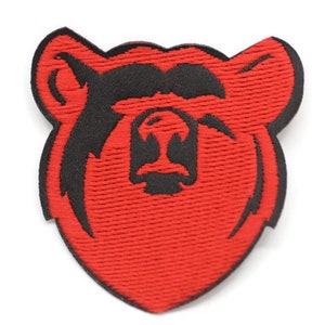 May include: Red embroidered patch of a bear's face with black outline.