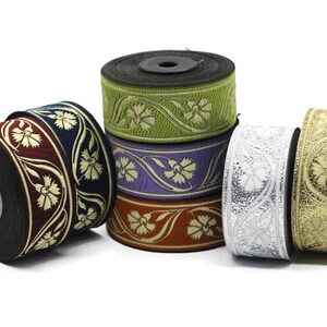 May include: A collection of decorative ribbon rolls in various colors, including burgundy, navy, green, purple, orange, silver, and gold. Each roll features a floral pattern in a contrasting color, suitable for crafts and embellishments.