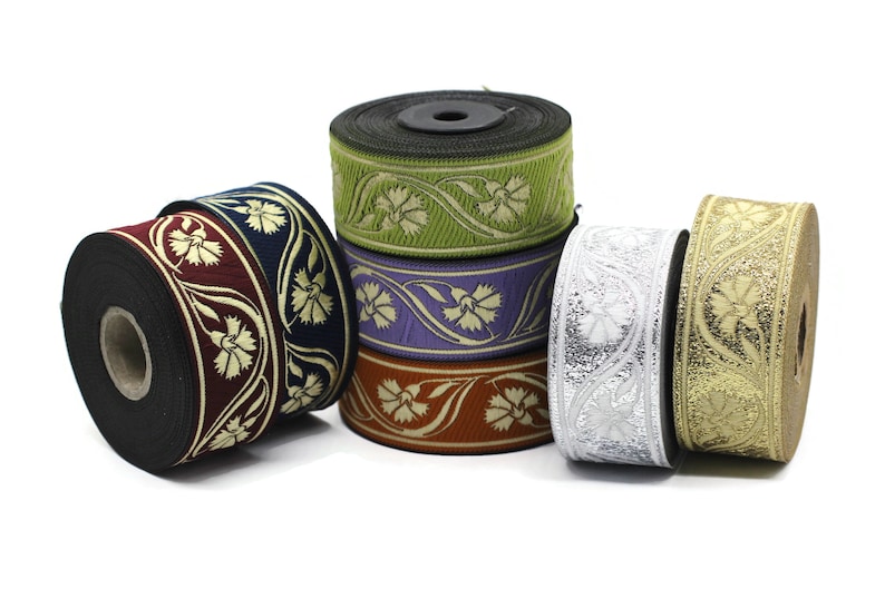 May include: A collection of decorative ribbon rolls in various colors, including burgundy, navy, green, purple, orange, silver, and gold. Each roll features a floral pattern in a contrasting color, suitable for crafts and embellishments.