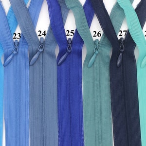 May include: Seven different colors of zipper tape, ranging from light blue to teal. The zippers are labeled with numbers 22 through 28.