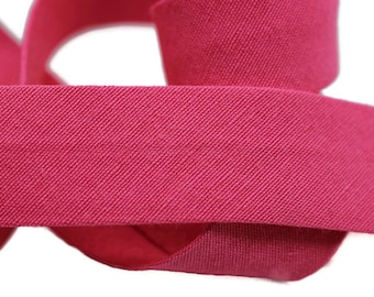 May include: A close-up of a pink elastic band, showing the textured weave of the fabric.
